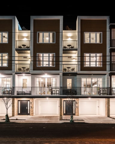 Modern vacation rental property at night with multiple balconies and large windows lit up