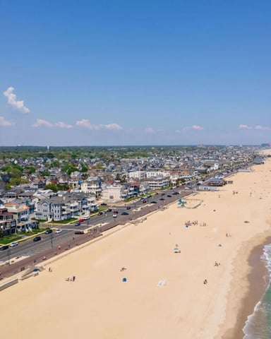 Aerial view of Jersey Shore beach with sandy shoreline, residential homes, and ocean waves