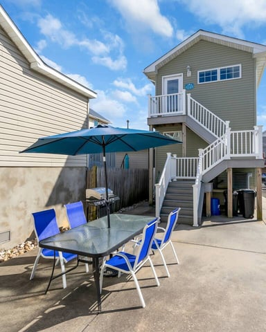 Outdoor patio with dining table and umbrella at a shore rental